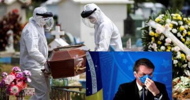 Sepultureros con trajes protectores llevan el ataúd de un fallecido por coronavirus.