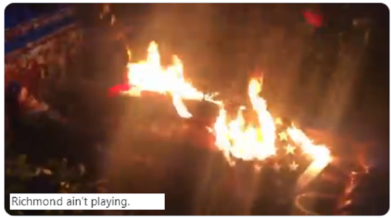 Manifestantes antirracistas derriban y prenden fuego una estatua de Cristóbal Colón junto a una bandera de EE.UU.
