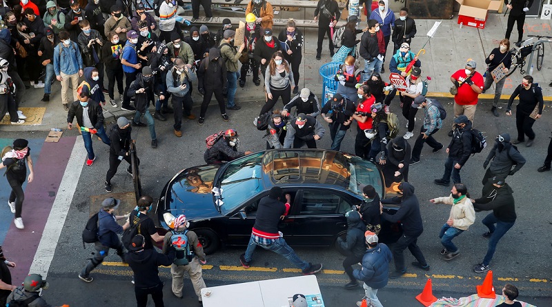Un hombre trata de abrir el coche de una persona que lo dirigió hacia una multitud durante las protestas en Seattle, EE.UU., el 7 de junio de 2020 (Lindsey Wasson / Reuters)
